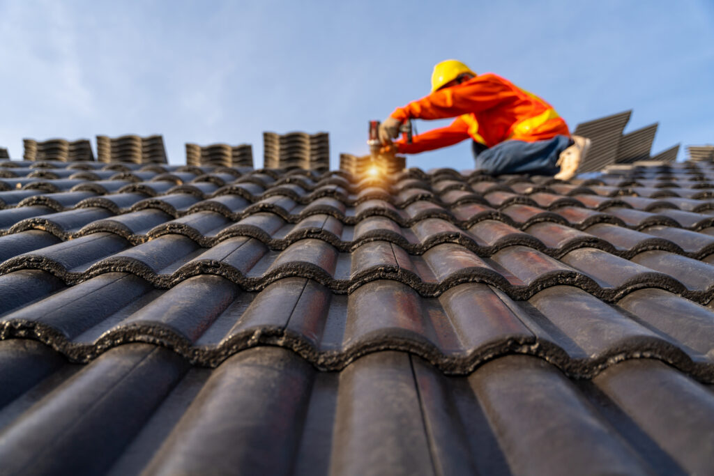 A Construction worker install new roof, Electric drill used on n